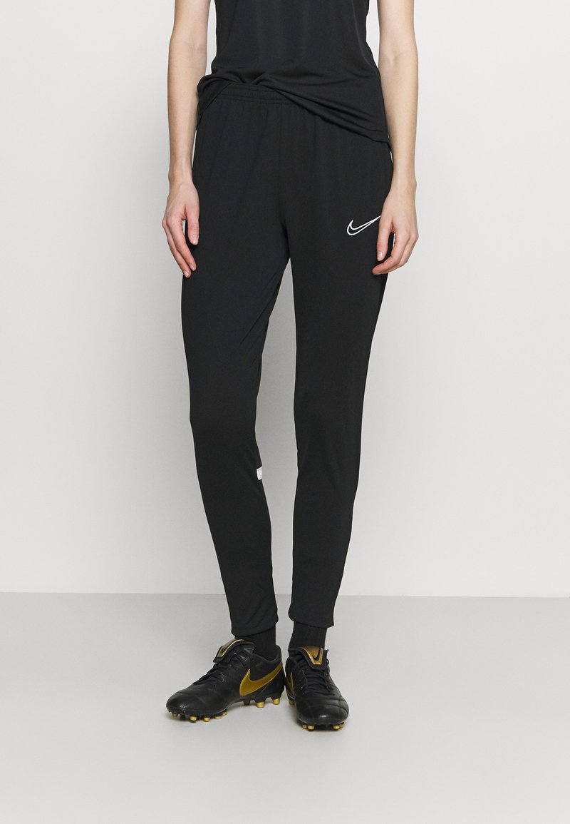 Black athletic pants with a tapered fit, elastic waistband, and side pockets. Features a white Nike logo on the left thigh.