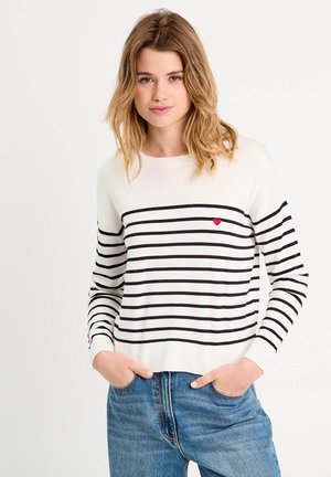Maglione a righe crema con righe nere, caratterizzato da un piccolo cuore rosso sul petto. Realizzato in un morbido materiale a maglia, vestibilità comoda e maniche lunghe.