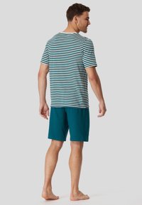 Striped cotton t-shirt in teal and white, paired with solid teal shorts. The shirt features a round neckline and short sleeves.