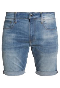 Vaaleansinisenä haalistuneilla yksityiskohdilla olevat farkkushortsit. Niissä on napillinen suljenta, viiden taskun malli, käännetyt lahkeet ja keltaiset ompeleet.