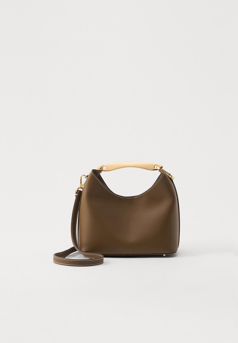 Barna bőr kézitáska ívelt dizájnnal, krém színű fogantyúval, arany hardware-rel és leválasztható vállpánttal. Fehér varrási részletekkel rendelkezik.