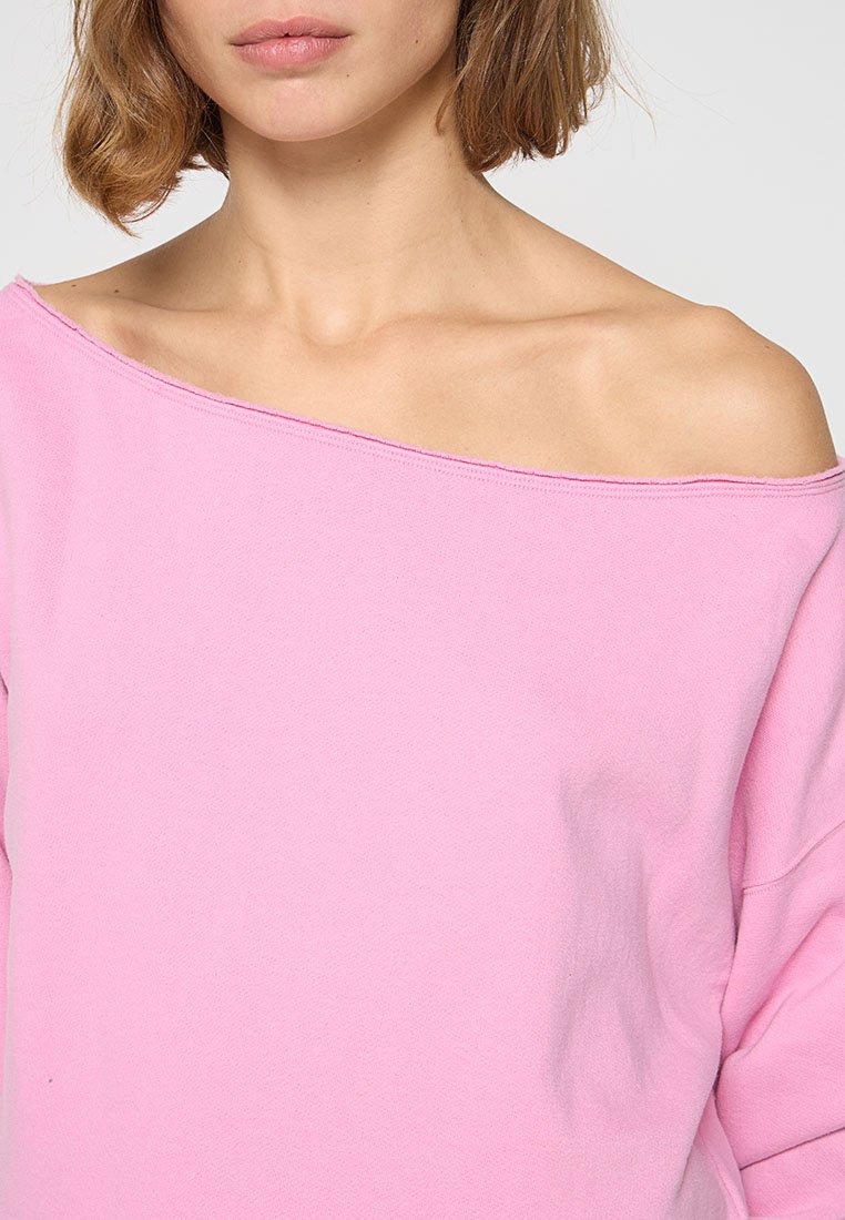 Rosa Schulterfreies Sweatshirt aus weicher Baumwolle. Mit lockerer Passform und sichtbaren Nähten entlang des Halsausschnitts.