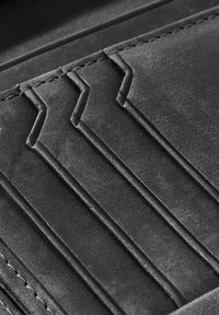 Black leather wallet featuring multiple card slots with angled edges, embossed detailing, and neat stitching along the seams.