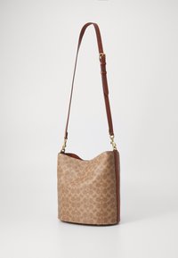 Brown patterned shoulder bag with a soft, slouchy shape, featuring a smooth leather strap and gold-tone hardware accents.