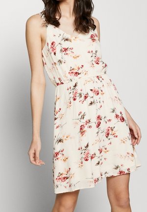 Bloemendress met een lichte crème basis, met roze en bruine bloemenpatronen. Mouwloos ontwerp met een elastische tailleband.