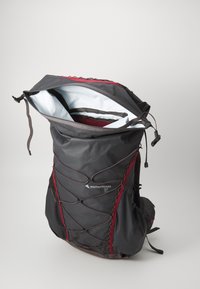 Black outdoor backpack with red accents, open top, and a textured outer fabric. Features adjustable straps and a spacious white interior.