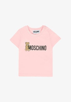 Różowa bluzka z krótkim rękawem z rysunkowym misiem oraz napisem "MOSCHINO" nadrukowanym na czarno na klatce piersiowej.