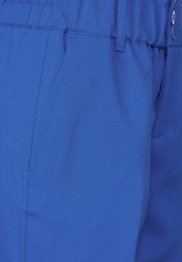 Blå byxor med en slät textur, med resår i midjan, sidofickor och en knappdetalj som framhäver en skräddarsydd passform.