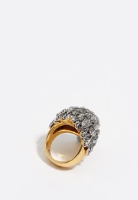Anillo de oro y plata con un diseño de hoja texturizada, con plata en un grupo sobre una ancha banda de oro.