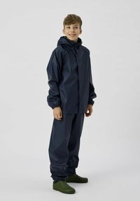 Marinblå vattentät regndräkt med elastiska manschetter, knäppning och matchande byxor. Djupgröna gummistövlar fulländar outfiten.