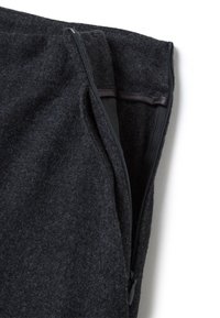 Tessuto grigio scuro con zip, caratterizzato da un materiale testurizzato simile alla lana, con una fodera interna visibile attraverso la zip aperta.