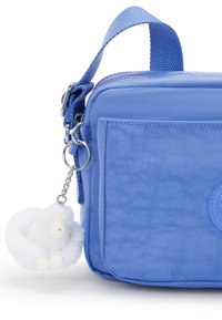 Borsa in nylon azzurro chiaro di forma rettangolare, con manico superiore, chiusura con zip e un portachiavi a forma di scimmietta bianca e pelosa attaccato.