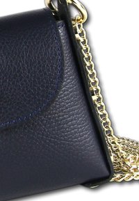 Sac en bandoulière en cuir bleu marine avec une surface texturée, une bandoulière en chaîne dorée et une fermeture à rabat incurvée. Accentué par des coutures contrastantes.