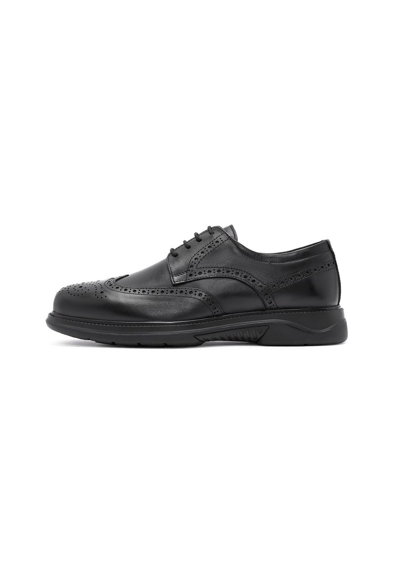 Chaussure brogue en cuir noir avec des perforations décoratives, un laçage et une semelle en caoutchouc, présentée de l'extérieur sur fond blanc.