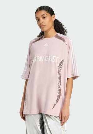 Maglietta corta rosa chiaro con maniche a giro, caratterizzata da dettagli decorativi in paillettes e il testo "TEAMGEIST", con logo Adidas bianco e dettagli a righe sulle spalle.