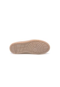 Semelle de chaussure en caoutchouc beige avec des motifs de traction texturés, comprenant des designs circulaires et linéaires, et un talon arrondi pour le soutien.
