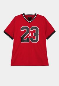 Červený síťovaný dres s černým véčkovým výstřihem, krátkými rukávy a velkým bílým číslem "23" s černým orámováním a ikonickým logem na zadní straně.