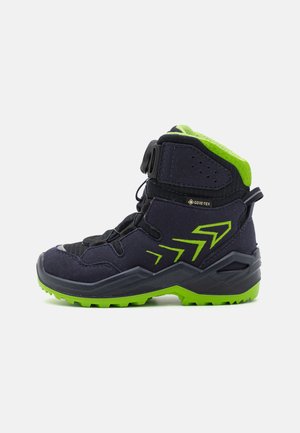 Schwarzer und grüner Stiefel für mittlere Wandertouren mit strukturiertem Obermaterial, Schnellzieh-System, gepolstertem Schaft und robustem Profil für besseren Halt.