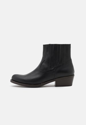 Bottines noires en cuir avec un bout arrondi, des panneaux latéraux élastiques et un talon empilé. Texture lisse et détails de couture minimalistes.