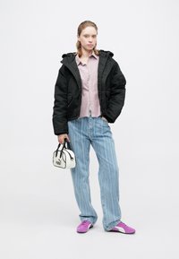 Melna pūka jaka, gaiši rozā pogaiņa krekls, zilas svītrainas džinsus, purpura apavus un nelielu baltu rokassomu ar melniem akcentiem.