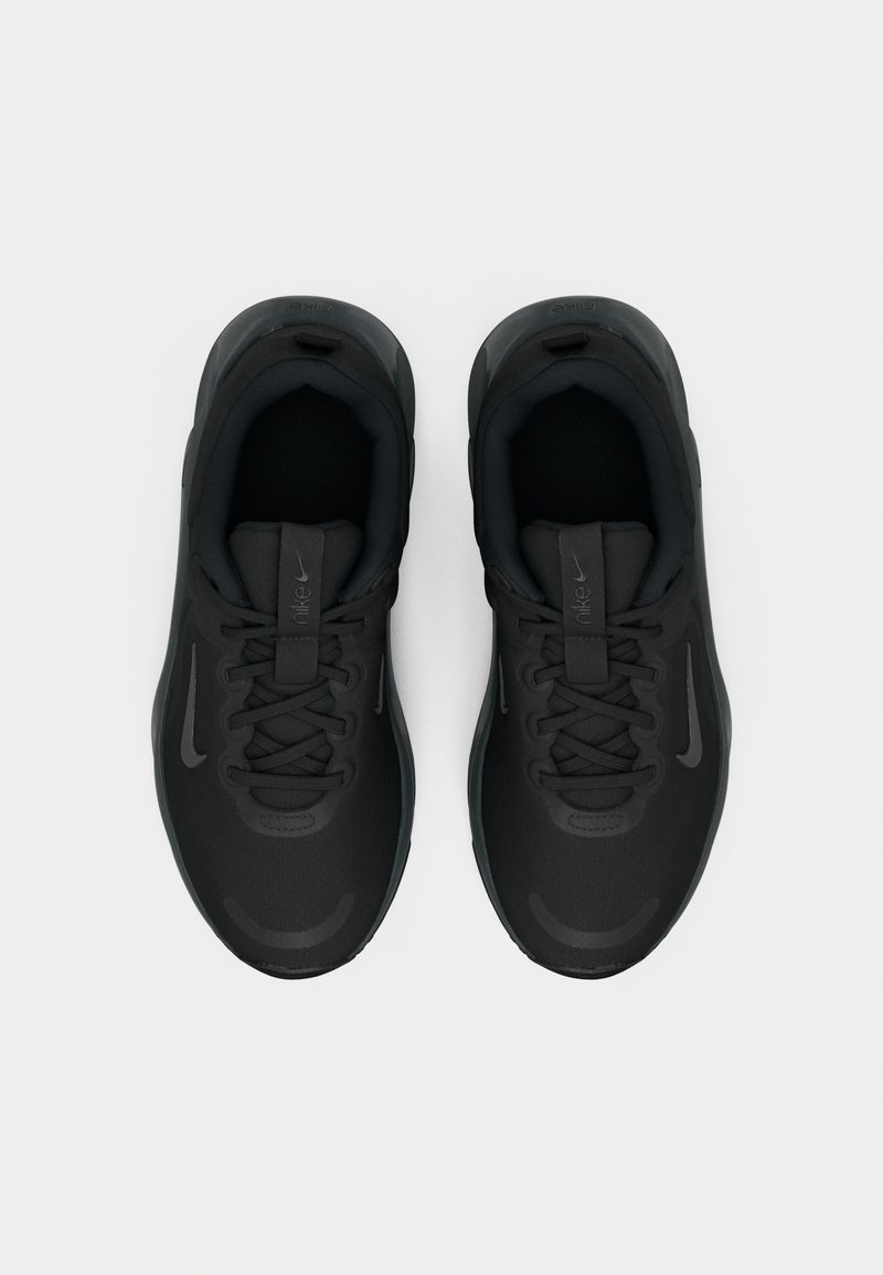 Un par de zapatillas de running negras de Nike con cordones, vistas desde arriba sobre un fondo blanco.