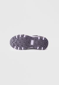 Suela de zapatilla negra y gris con un patrón de banda de rodadura resistente, que presenta tacos pronunciados para mayor tracción y acentos de goma blanca.