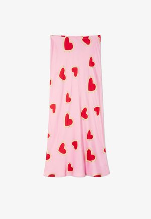 Jupe rose avec un ourlet évasé, présentant un motif de grands cœurs rouges bordés de beige avec de petits points.