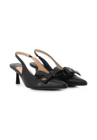 Tacones negros tipo slingback en piel texturizada con punta afilada y un gran lazo decorativo. Presentan un pequeño acento dorado en el lazo y un tacón de altura media.