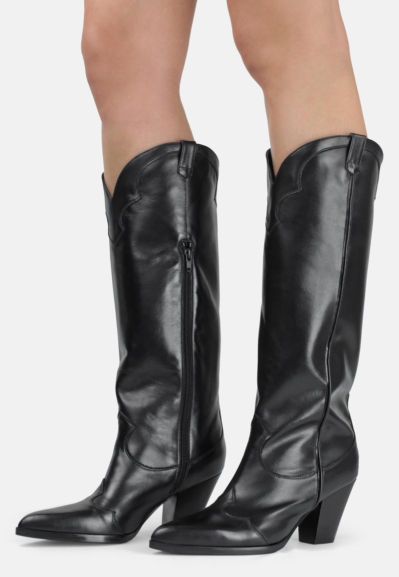 Botas de cuero negras hasta la rodilla con punta afilada, cierre de cremallera y costuras decorativas texturizadas a lo largo de los bordes y los lados.