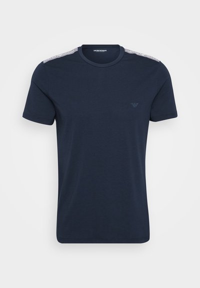 T-shirt en coton bleu marine à manches courtes, encolure ronde et logo texturé sur la poitrine gauche. Accent blanc sur l'épaule avec marquage.