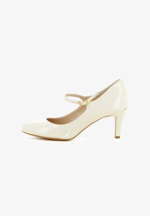 Chaussure Mary Jane à talon haut en cuir verni crème, bout arrondi et bride à boucle dorée sur fond blanc.
