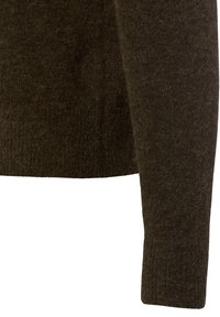 Donkerbruin gebreide trui, gemaakt van zachte wol, met een gestructureerde afwerking en fitted mouwen. De onderrand is ribbelig voor extra detail.