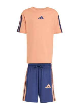 T-shirt à manches courtes couleur pêche avec rayures bleu marine et logo, associé à un short bleu marine avec rayures pêche et logo assorti.
