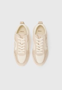 Beige och krämfärgade sneakers med en blandning av släta och mocka-texturer, rundade former, snörning och subtil logodesign.
