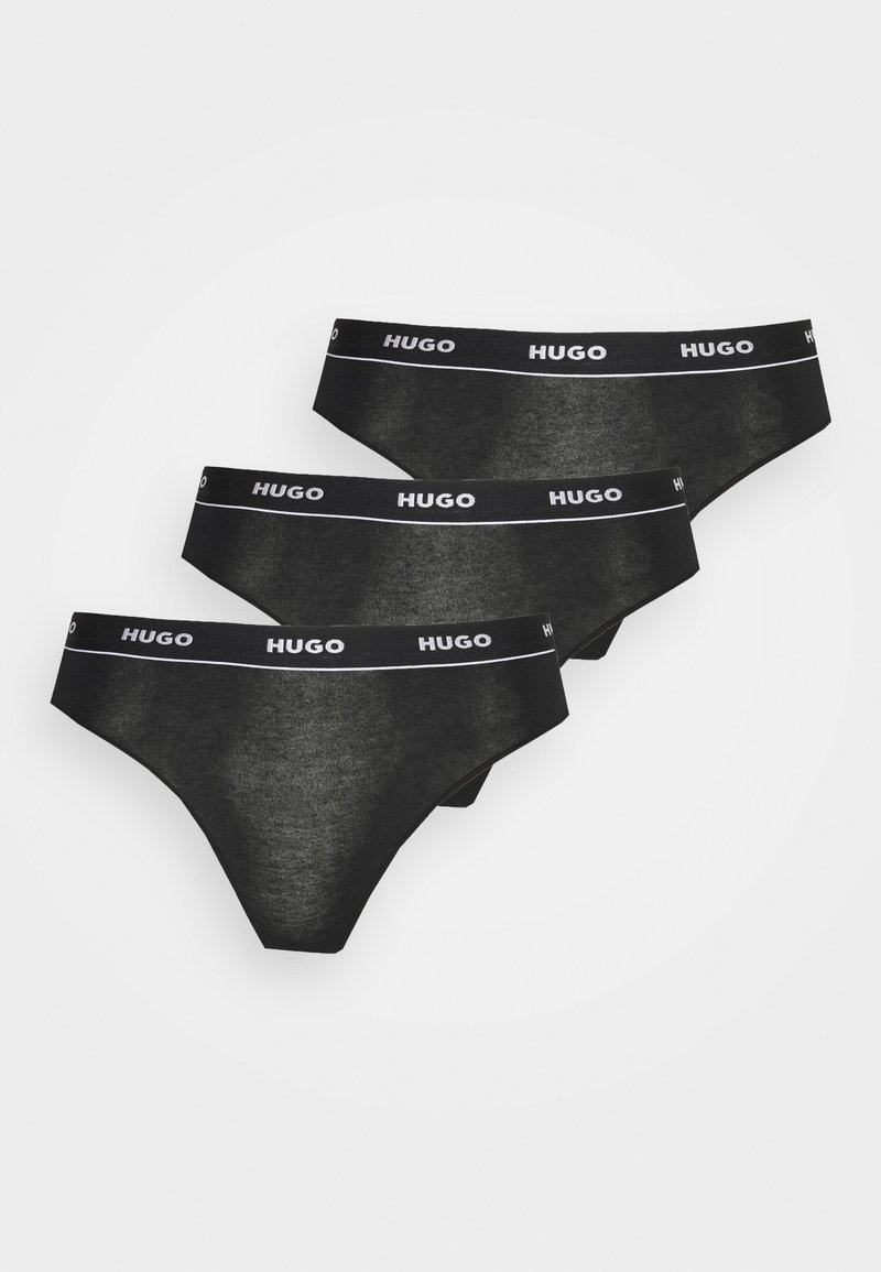 Ensemble de trois slips en coton noir, avec une taille élastique blanche portant le logo "HUGO", texture lisse et design minimaliste.