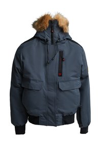 Tumši zila pufīgā jaka ar kažokādas odere kapuci, divām priekšējām kabatām, vertikālu rāvējslēdzēja kabatu, kā arī elastīgām aprocēm un jostiņu.