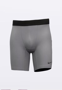 Hallid spordipüksid musta vöökohaga, valmistatud siledast kangast. Vasakul küljel on logoga ning need on keha järgiva lõikega.