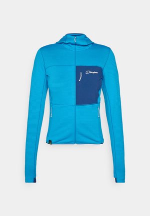 Modra zip-up jakna z teksturirano površino, kontrastno temno modrim žepom na prsih in zadrgami, zasnova, ki se prilega, in kapuco za dodatno zaščito.