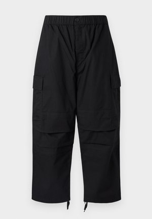 Svarte cargobukser med elastisk midjebånd, flere lommer og glidelåser ved anklene, med en avslappet, vid passform.