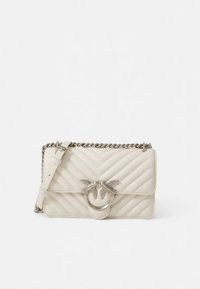 Borsa a tracolla in pelle trapuntata color crema con chiusura a forma di uccello argentato e tracolla a catena su sfondo bianco.