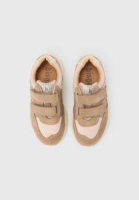 Paire de baskets pour tout-petits beige et rose avec deux bandes velcro et logo de la marque sur la languette, vue de dessus sur fond blanc.