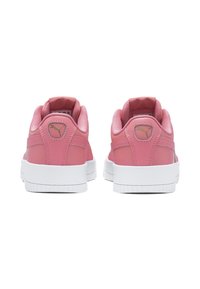 Pink sneakers with smooth synthetic upper, white rubber sole, and padded collar. Small logo detail near heel.