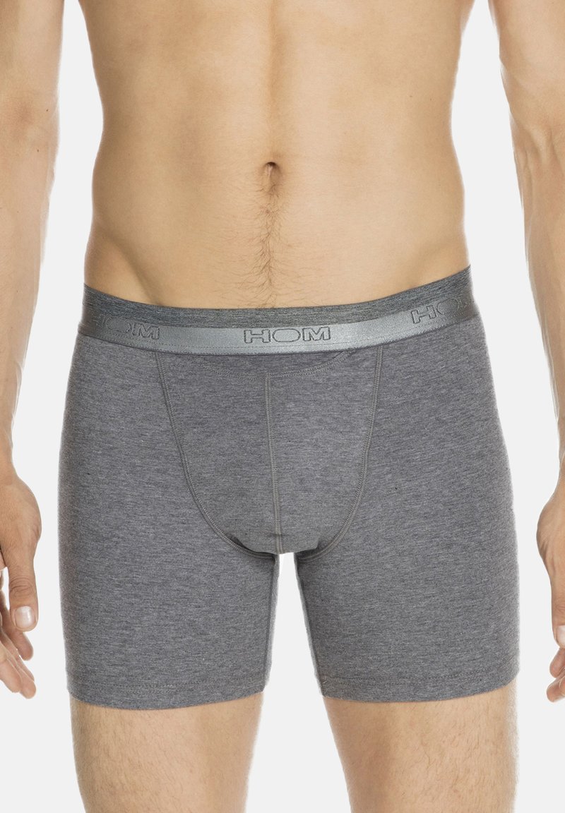 Boxer in cotone grigio con una cintura argento a contrasto che presenta il logo "HOM"; lunghezza fino a metà coscia con una linea aderente e una texture liscia.