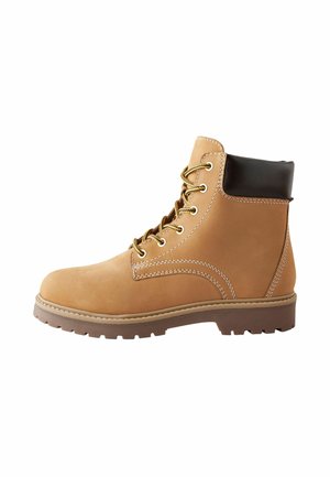 Bottines en cuir marron à lacets avec bout rond, col en cuir noir contrastant et semelle en caoutchouc texturée ; coutures visibles et détails en matériel.