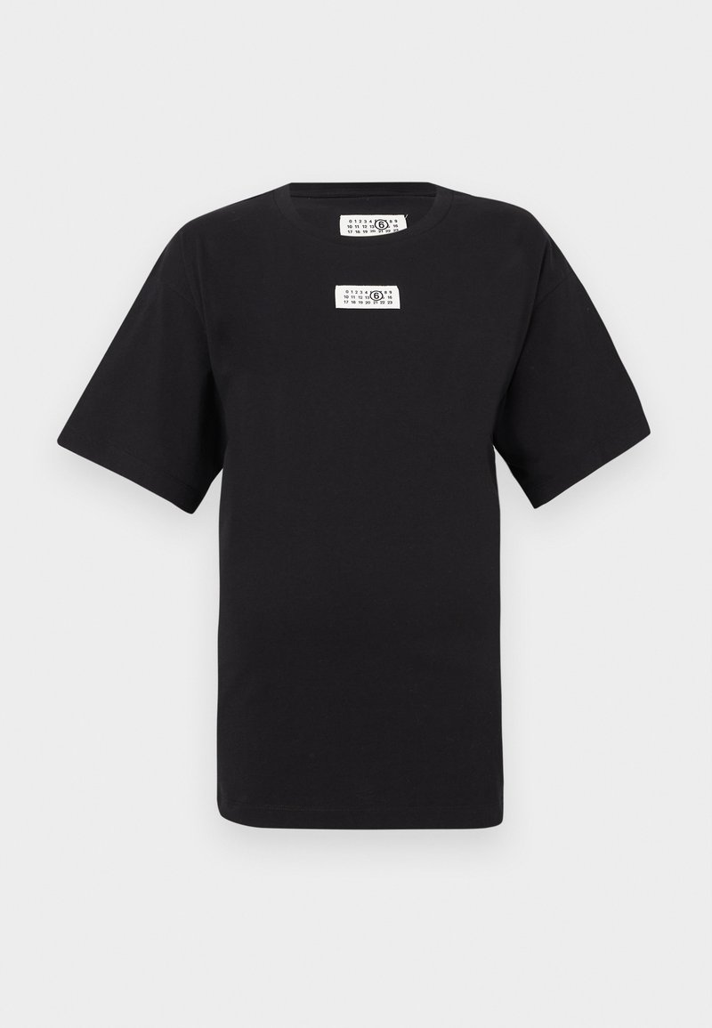 T-shirt noir en coton avec col rond, manches courtes, et deux étiquettes blanches à l'avant. Le tissu semble lisse et doux.