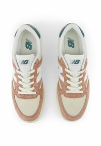 Kevyet urheilujalkineet, joissa on kerma-vaalea verkkokangas päällinen, vaaleanpunaiset mokka-yksityiskohdat, valkoinen logo ja nauhat; kumipohja pitoon.