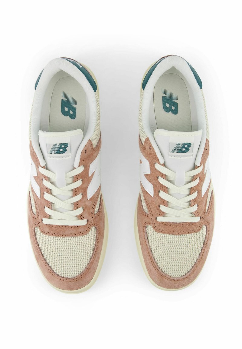 Zapatillas deportivas ligeras con parte superior de malla color crema, acentos de ante rosa, logo blanco y cordones; suela de goma para tracción.