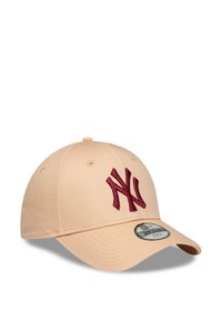 Beige Baseballcap mit gebogenem Schirm, maroonfarbenem gesticktem "NY"-Logo auf der Vorderseite und einem schwarz-weißen runden Aufkleber auf dem Schirm.