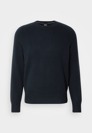 Maglione girocollo di un blu navy scuro realizzato in morbido materiale a maglia, con polsini e orlo a costine e un design delle spalle senza cuciture.