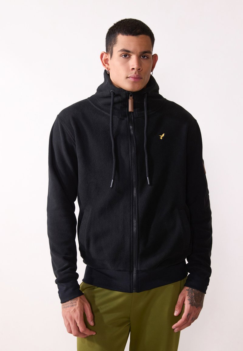Felpa nera in fleece con zip e colletto alto, cordini regolabili e tasche frontali. Presenta un logo d'oro sul petto e polsini a costine.